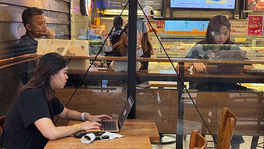 Pengunjung menggunakan laptop di salah satu pusat perbelanjaan di Jakarta, Senin (29/12/2025). (Bloomberg Technoz/Andrean Kristianto)