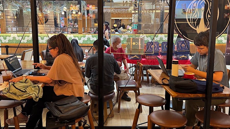 Pengunjung menggunakan laptop di salah satu pusat perbelanjaan di Jakarta, Senin (29/12/2025). (Bloomberg Technoz/Andrean Kristianto) 