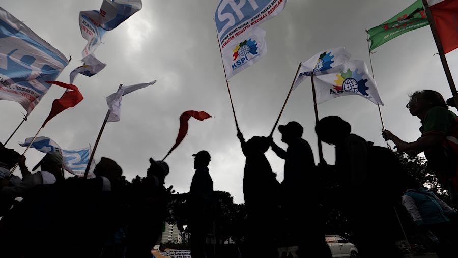 Sejumlah massa buruh menggelar aksi unjuk rasa di Jalan Medan Merdeka Selatan, Jakarta, Selasa (30/12/2025). (Bloomberg Technoz/Andrean Kristianto)