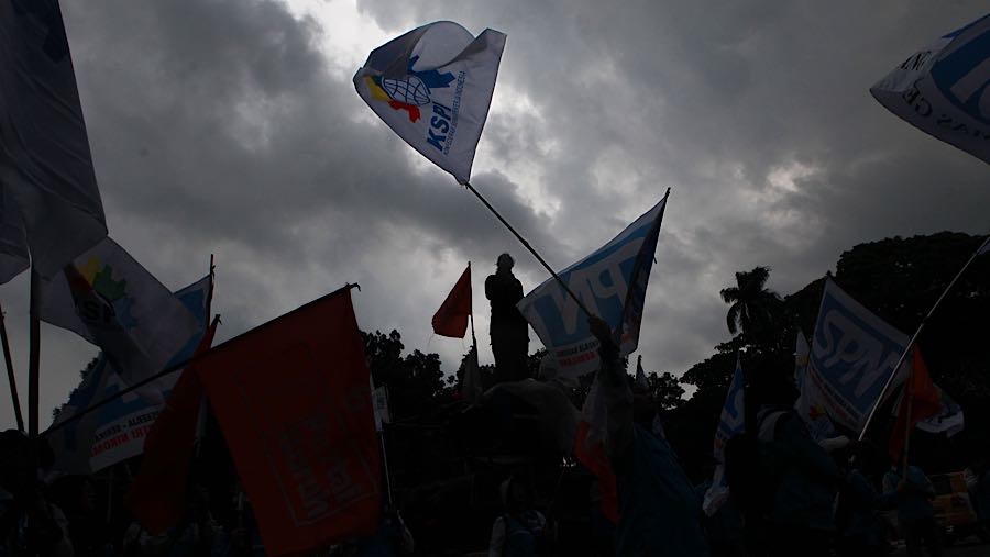 Sejumlah massa buruh menggelar aksi unjuk rasa di Jalan Medan Merdeka Selatan, Jakarta, Selasa (30/12/2025). (Bloomberg Technoz/Andrean Kristianto)