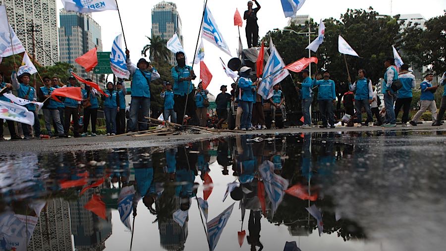 Sejumlah massa buruh menggelar aksi unjuk rasa di Jalan Medan Merdeka Selatan, Jakarta, Selasa (30/12/2025). (Bloomberg Technoz/Andrean Kristianto)