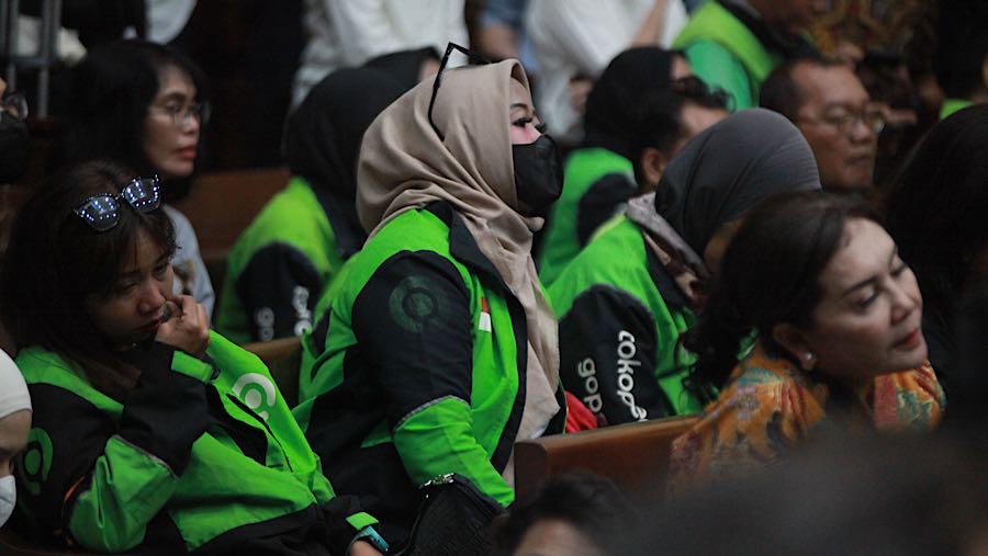 Di dalam ruang sidang nampak beberapa orang mengenakan jaket dari perusahaan penyedia layanan transportasi daring, PT Gojek Indonesia.