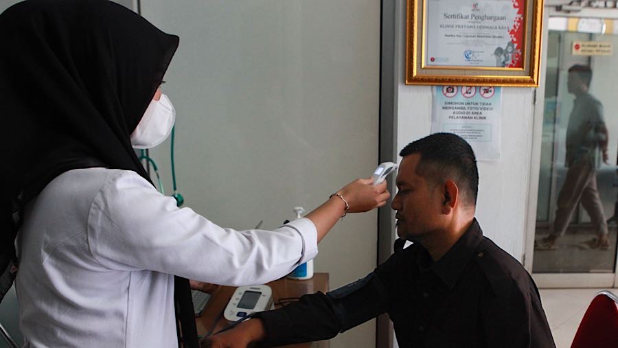 Petugas medis melakukan pemeriksaan kesehatanbdi Klinik Dermaga Raya, Jakarta, Selasa (6/1/2026). (Bloomberg Technoz/Andrean Kristianto)