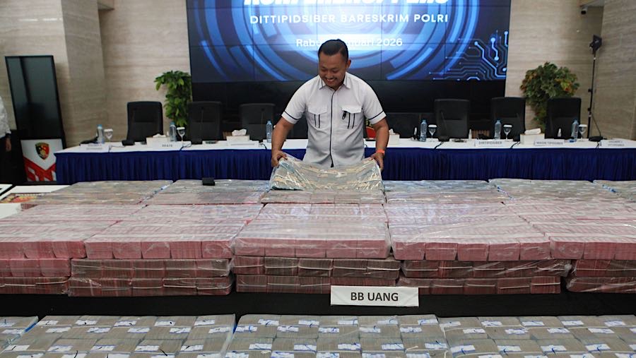 Petugas menata barang bukti praktik judi online (judol) di Bareskrim Polri, Jakarta, Rabu (7/1/2026). (Bloomberg Technoz/Andrean Kristianto)