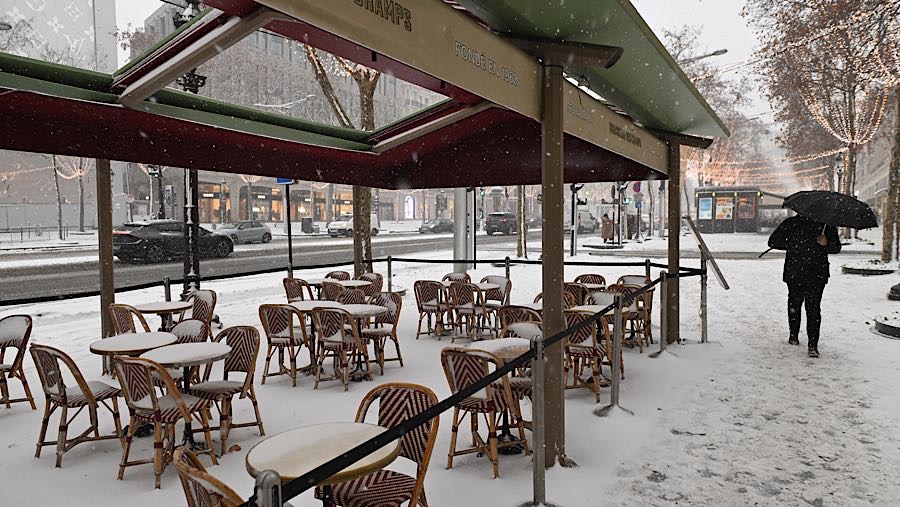 Meja-meja kafe kosong tertutup salju saat cuaca dingin di Paris, Prancis, Rabu (7/1/2026).(Benjamin Girette/Bloomberg)
