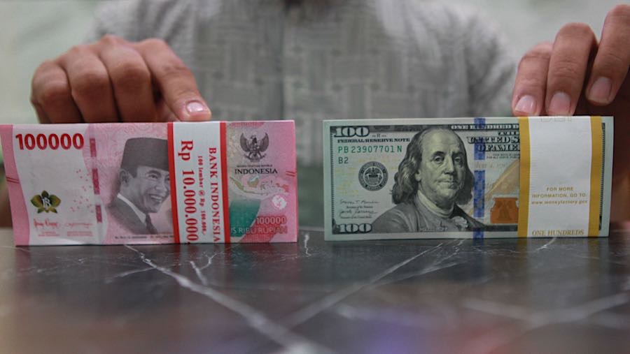 Karyawan merapihkan uang dolar AS dan rupiah di salah satu tempat penukaran uang di Jakarta, Jumat (9/1/2026). (Bloomberg Technoz/Andrean Kristianto)