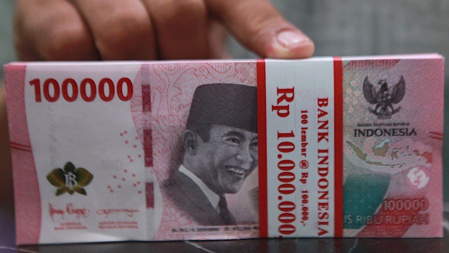 Karyawan merapihkan uang rupiah di salah satu tempat penukaran uang di Jakarta, Jumat (9/1/2026). (Bloomberg Technoz/Andrean Kristianto)