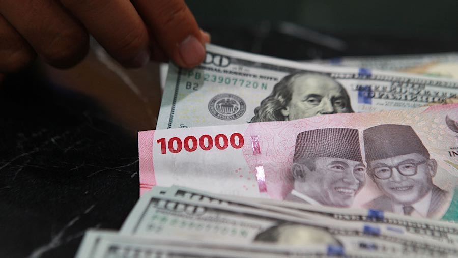 Karyawan merapihkan uang dolar AS dan rupiah di salah satu tempat penukaran uang di Jakarta, Jumat (9/1/2026). (Bloomberg Technoz/Andrean Kristianto)