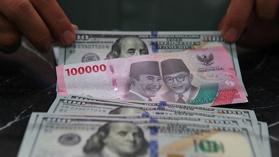 Karyawan merapihkan uang dolar AS dan rupiah di salah satu tempat penukaran uang di Jakarta, Jumat (9/1/2026). (Bloomberg Technoz/Andrean Kristianto)