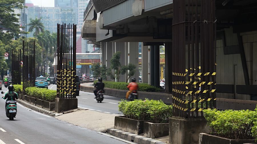 Kendaraan melintas di dekat tiang monorel yang mangkrak di Jalan Rasuna Said, Jakarta, Rabu (14/1/2026). (Bloomberg Technoz/Andrean Kristianto)
