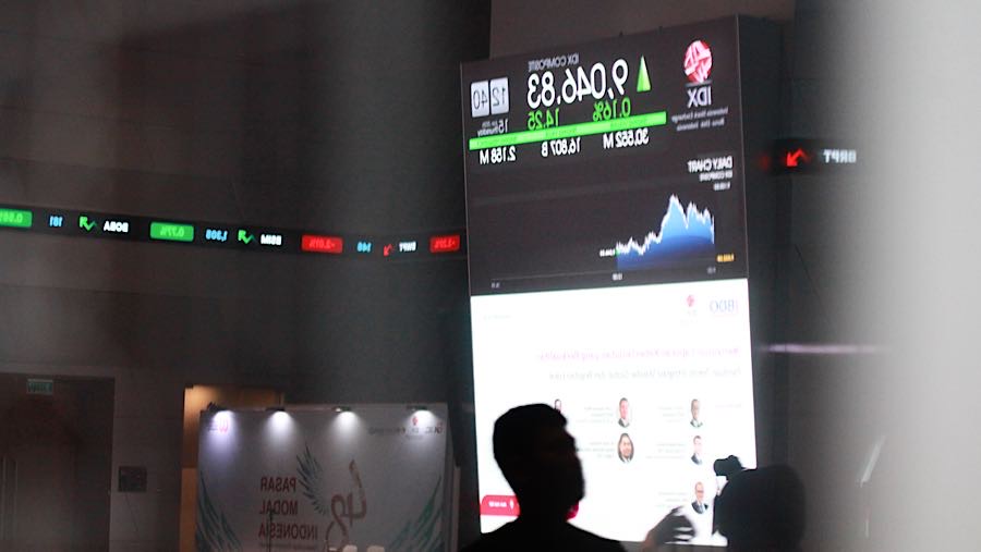 Pengunjung melintas di depan layar pergerakan harga saham (IHSG) di Bursa Efek Indonesia (BEI), Jakarta, Kamis (15/1/2026) (Bloomberg Technoz/Andrean)