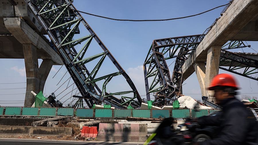 Crane tersebut digunakan dalam pembangunan jalan layang dan jatuh menimpa badan jalan di bawahnya. (Valeria Mongelli/Bloomberg)