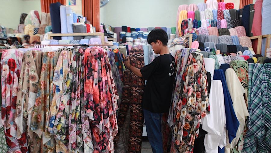 Pedagang merapihkan bahan kain tekstil yang dijual di Cipadu, Kota Tangerang, Banten, Senin (19/1/2026). (Bloomberg Technoz/ Andrean Kristianto)
