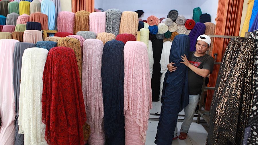 Pedagang merapihkan bahan kain tekstil yang dijual di Cipadu, Kota Tangerang, Banten, Senin (19/1/2026). (Bloomberg Technoz/ Andrean Kristianto)