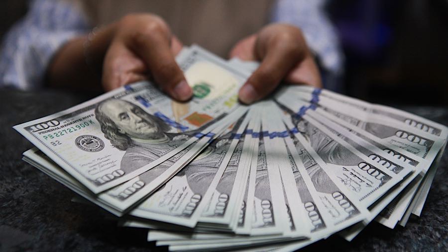 Pekerja menghitung uang dolar AS di tempat penukaran mata uang asing di Jakarta, Senin (19/1/2026). (Bloomberg Technoz/ Andrean Kristianto)