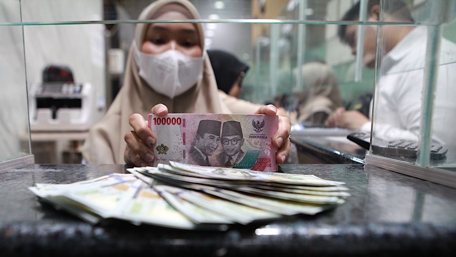 Pekerja menghitung uang rupiah di tempat penukaran mata uang asing di Jakarta, Senin (19/1/2026). (Bloomberg Technoz/ Andrean Kristianto)