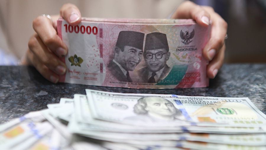 Pekerja menghitung uang rupiah di tempat penukaran mata uang asing di Jakarta, Senin (19/1/2026). (Bloomberg Technoz/ Andrean Kristianto)
