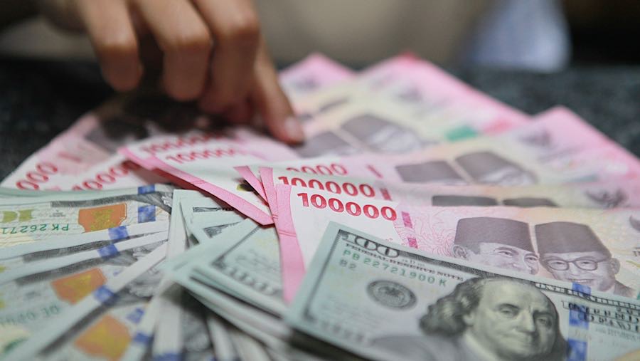 Pekerja menghitung uang rupiah di tempat penukaran mata uang asing di Jakarta, Senin (19/1/2026). (Bloomberg Technoz/ Andrean Kristianto)
