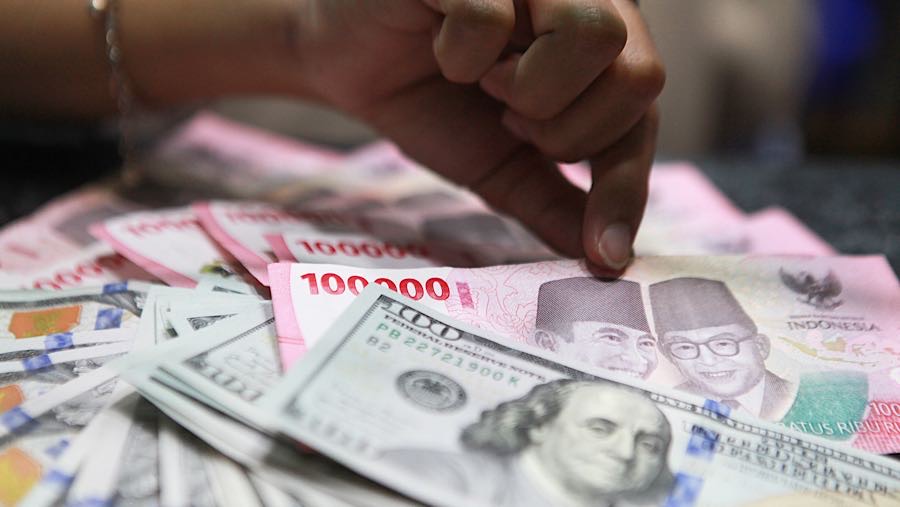 Pekerja menghitung uang rupiah di tempat penukaran mata uang asing di Jakarta, Senin (19/1/2026). (Bloomberg Technoz/ Andrean Kristianto)
