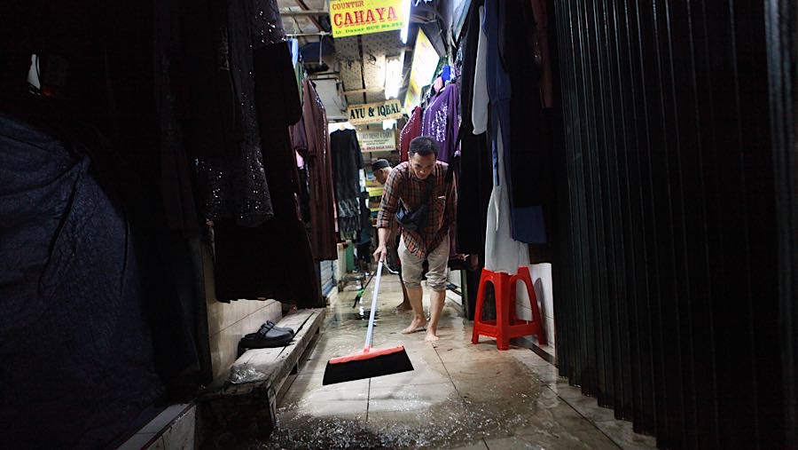 Pedagang membersihkan genangan air di Pasar Cipulir, Jakarta, Jumat (23/1/2026). (Bloomberg Technoz/Andrean Kristianto)