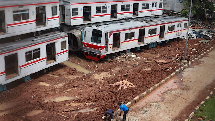 Pekerja di dekat gerbong KRL Commuter Line yang tidak beroperasi di Depo KRL Depok, Senin (26/1/2026). (Bloomberg Technoz/Andrean Kristianto)