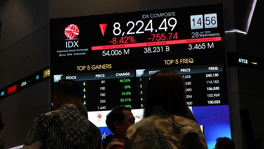 Pengunjung di depan layar pergerakan harga saham (IHSG) di Bursa Efek Indonesia (BEI), Rabu (28/1/2026). (Bloomberg Technoz/Andrean Kristianto)