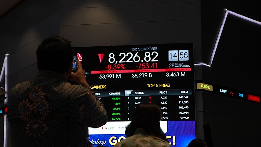 Pengunjung di depan layar pergerakan harga saham (IHSG) di Bursa Efek Indonesia (BEI), Rabu (28/1/2026). (Bloomberg Technoz/Andrean Kristianto)