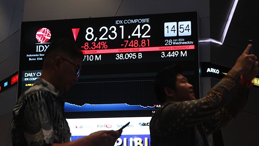 Pengunjung di depan layar pergerakan harga saham (IHSG) di Bursa Efek Indonesia (BEI), Rabu (28/1/2026). (Bloomberg Technoz/Andrean Kristianto)