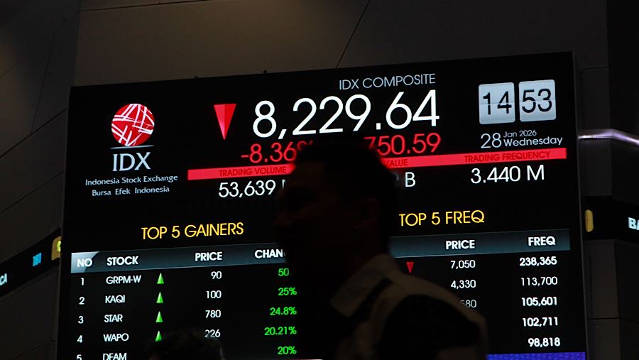 Pengunjung di depan layar pergerakan harga saham (IHSG) di Bursa Efek Indonesia (BEI), Rabu (28/1/2026). (Bloomberg Technoz/Andrean Kristianto)