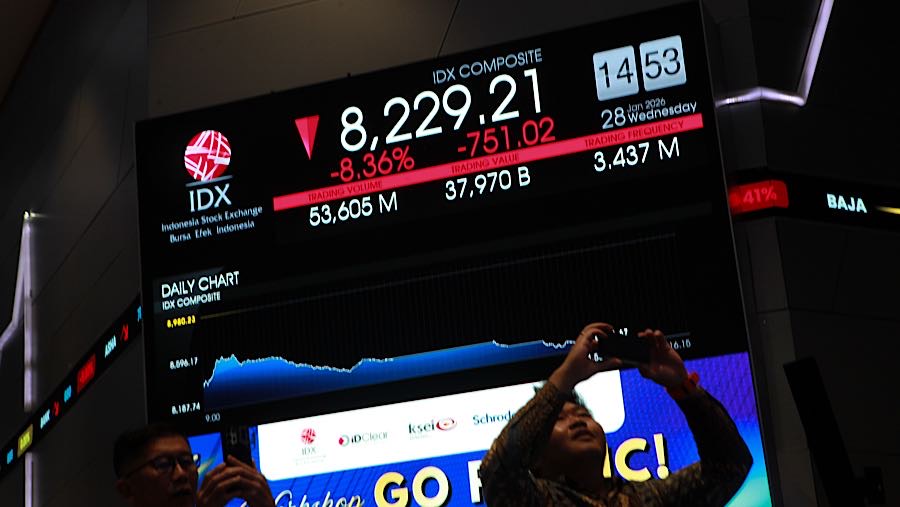 Pengunjung di depan layar pergerakan harga saham (IHSG) di Bursa Efek Indonesia (BEI), Rabu (28/1/2026). (Bloomberg Technoz/Andrean Kristianto)