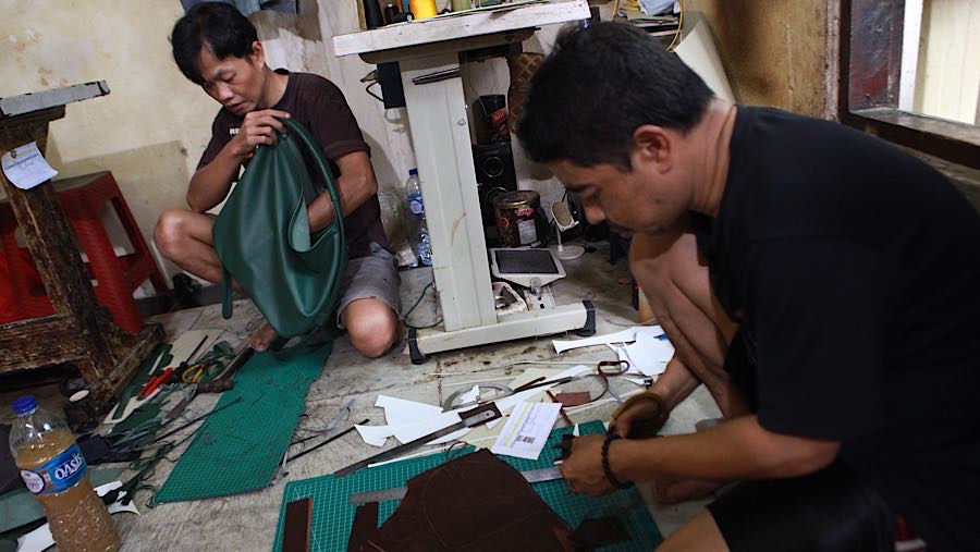 Pengrajin menyelesaikan pembuatan tas di Jakarta, Jumat (30/1/2026). (Bloomberg Technoz/Andrean Kristianto)