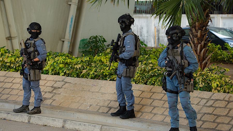 Polisi bersenjata lengkap juga terlihat berjaga diluar pengadilan saat sidang vonis mantan taipan media Jimmy Lai. (Lam Yik/Bloomberg)