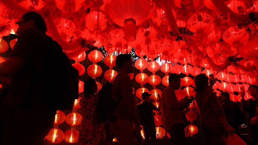 Warga melintas di depan dekorasi Festival Imlek Jakarta di Bundaran HI, Jakarta, Jumat (13/2/2026). (Bloomberg Technoz/Andrean Kristianto)