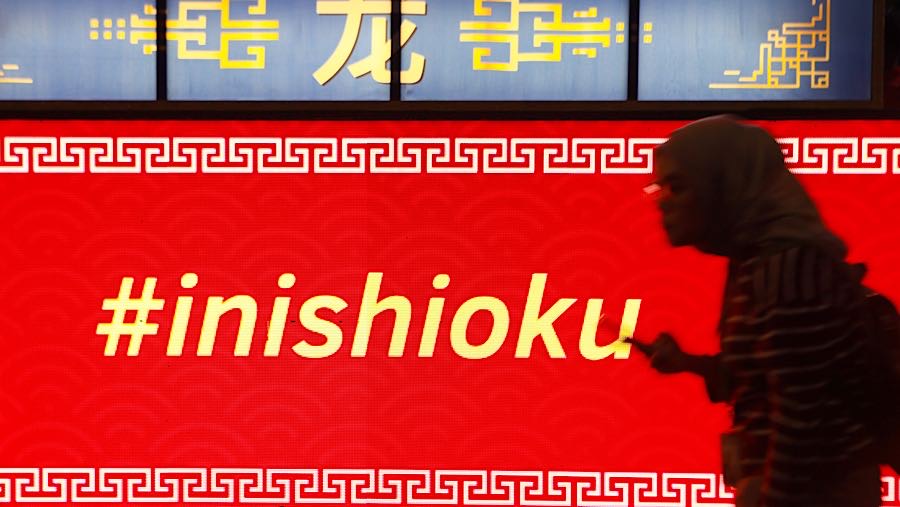 Warga melintas di depan dekorasi Festival Imlek Jakarta di Bundaran HI, Jakarta, Jumat (13/2/2026). (Bloomberg Technoz/Andrean Kristianto)