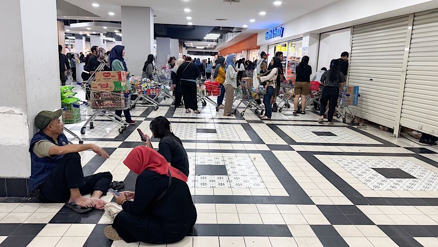 Beberapa pengunjung juga terlihat duduk di lantai sambil menunggu keluarganya yang berbelanja. (Bloomberg Technoz/Andrean Kristianto)