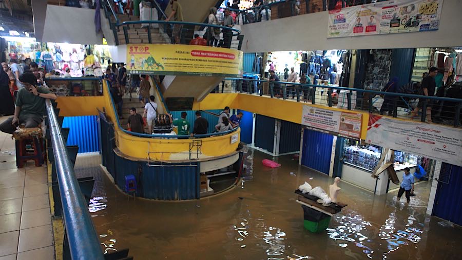 Pedagang di lantai dua melanjutkan aktivitas mereka meskipun jumlah pembeli berkurang karena kondisi pasar yang terendam. (Bloomberg Technoz/Andrean)
