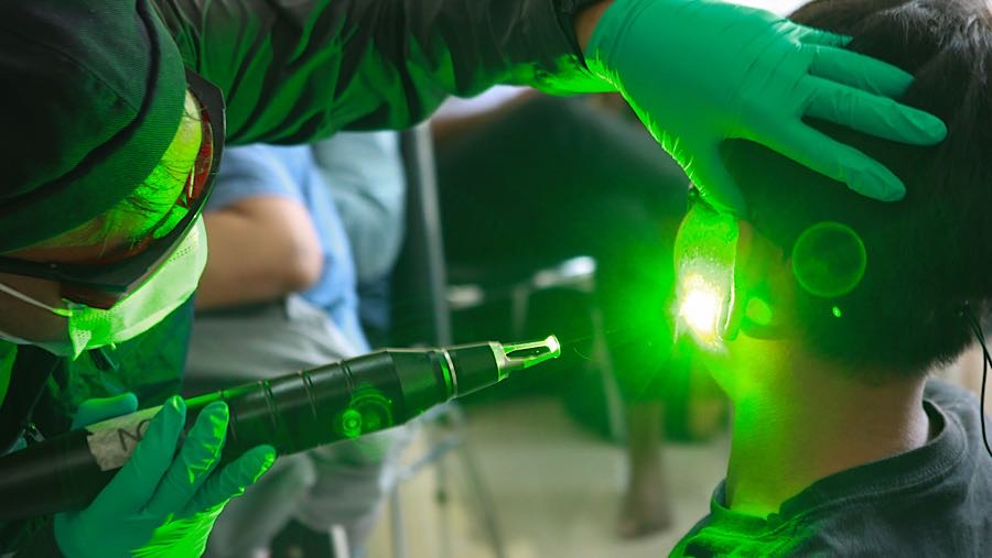 Petugas menghapus tato peserta menggunakan laser di Masjid Sunda Kelapa, Jakarta, Senin (23/2/2026). (Bloomberg Technoz/Andrean Kristianto)