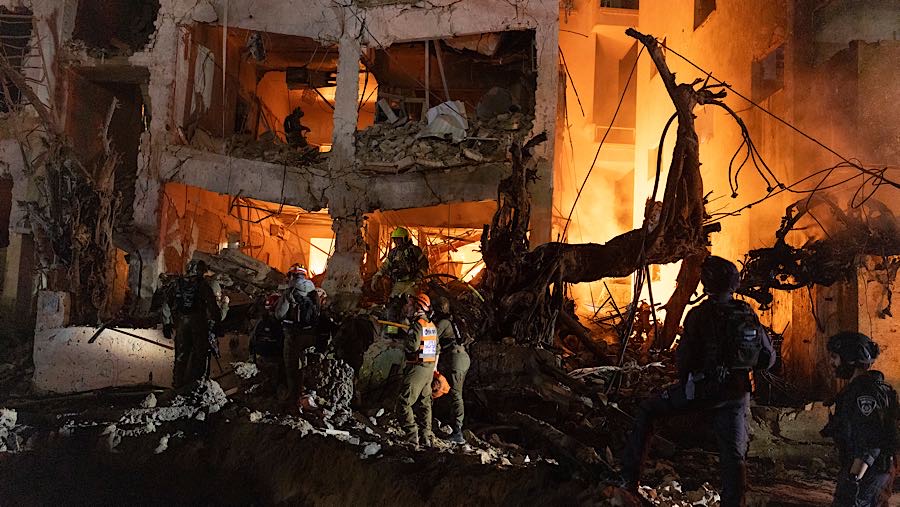 Petugas bekerja di sebuah gedung yang  rusak terkena serangan rudal Iran di Tel Aviv, Israel, Sabtu (28/2/2026). (Kobi Wolf/Bloomberg)