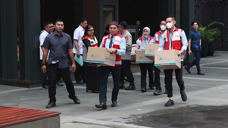 Petugas DPJK OJK membawa barang hasil sitaan penggeledahan di kantor sekuritas di Gedung Treasury Tower, Rabu (4/3/2026). (Bloomberg Technoz/Andrean)