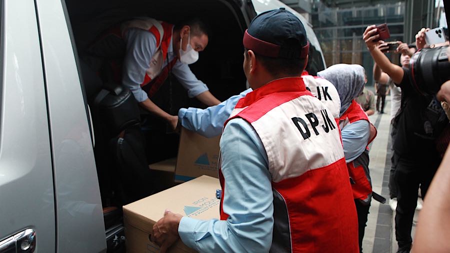 Petugas DPJK OJK membawa barang hasil sitaan penggeledahan di kantor sekuritas di Gedung Treasury Tower, Rabu (4/3/2026). (Bloomberg Technoz/Andrean)