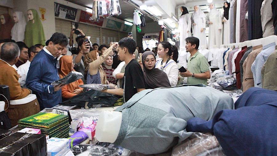 Purbaya terlihat beberapa kali mencoba pakaian dari salah satu pedagang dan membelinya. (Bloomberg Technoz/Andrean Kristianto)