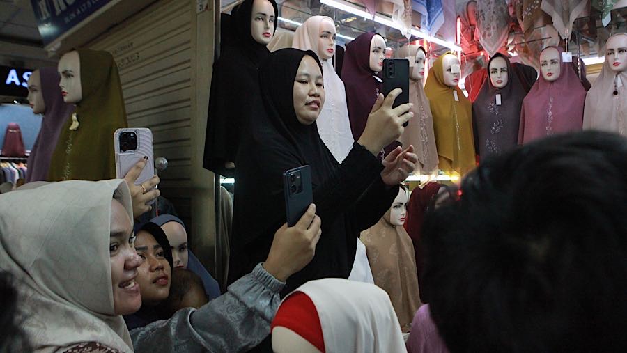 Momen kunjungan Menkeu Purbaya disambut antusias oleh para pedagang dengan merekam dengan gawainya. (Bloomberg Technoz/Andrean K)