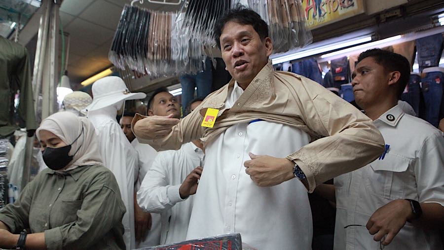 Menteri Keuangan Purbaya Yudhi Sadewa mencoba pakaian yang dijual di Pasar Tanah Abang, Senin (9/3/2026). (Bloomberg Technoz/Andrean Kristianto)