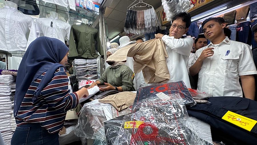 Menteri Keuangan Purbaya Yudhi Sadewa mencoba pakaian yang dijual di Pasar Tanah Abang, Senin (9/3/2026). (Bloomberg Technoz/Andrean Kristianto)