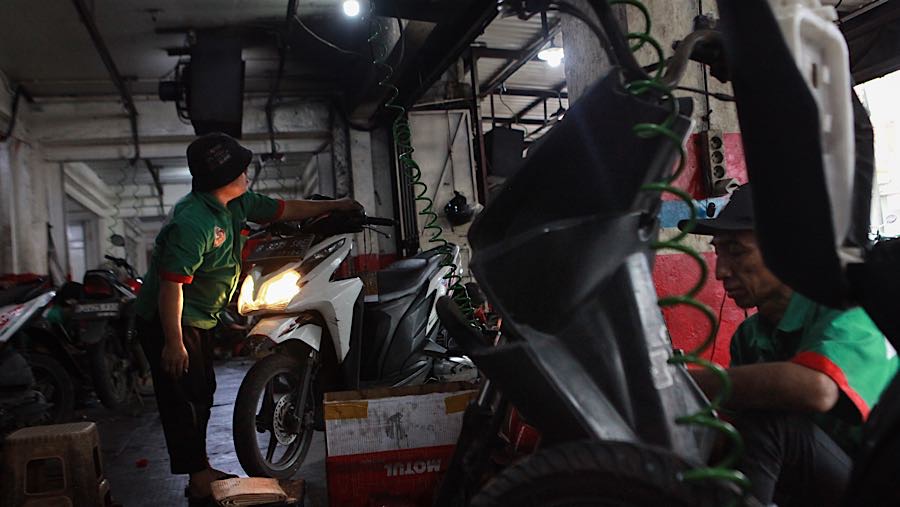 Mekanik memperbaiki sepeda motor di bengkel kawasan Pasar Minggu, Jakarta Selatan, Selasa (10/3/2026). (Bloomberg Technoz/Andrean Kristianto)