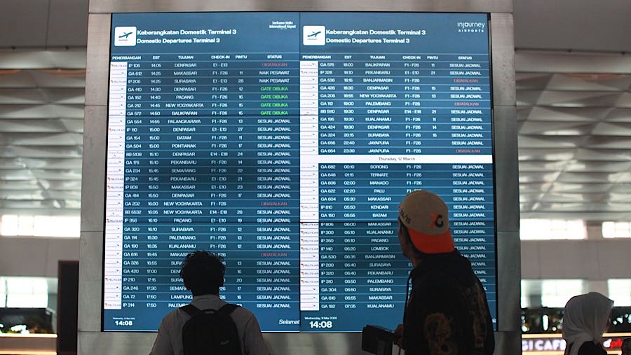 Calon penumpang melihat papan keberangkatan maskapai di Terminal 3 Bandara Soekarno-Hatta, Rabu (11/3/2026). (Bloomberg Technoz/Andrean Kristianto)