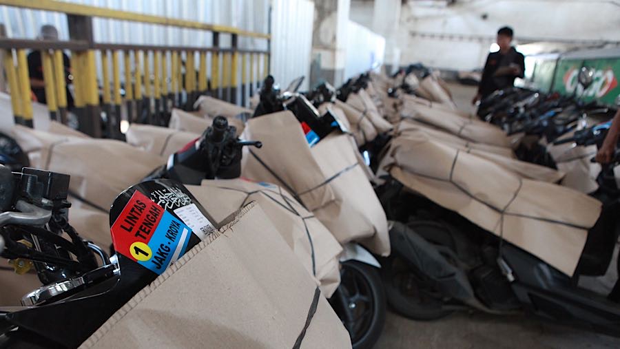 Petugas merapikan motor peserta program Angkutan Motis di Stasiun Jakarta Gudang, Kamis (12/3/2026). (Bloomberg Technoz/Andrean Kristianto)
