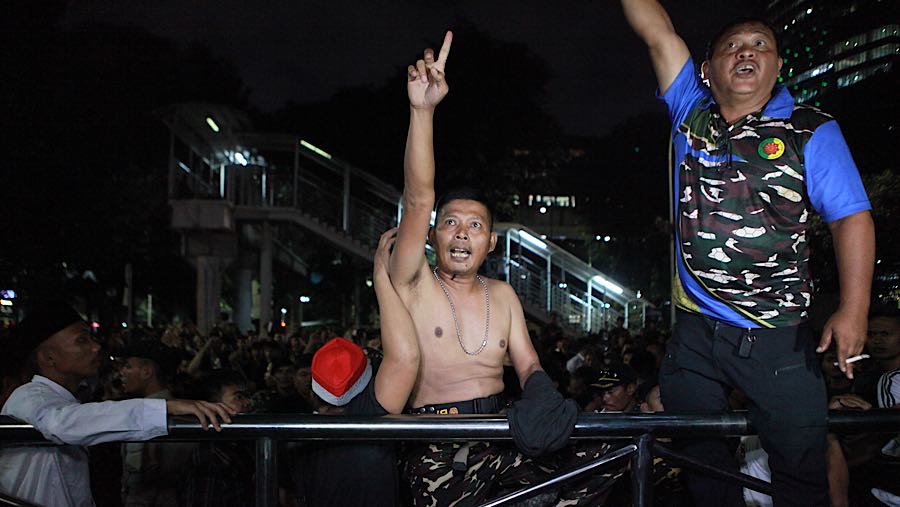 Para Banser tersebut meneriaki nama Yaqut dengan Gus Yaqut berkali-kali saat mobil tahanan membawa mantan Menag tersebut. (Bloomberg Technoz/Andre)