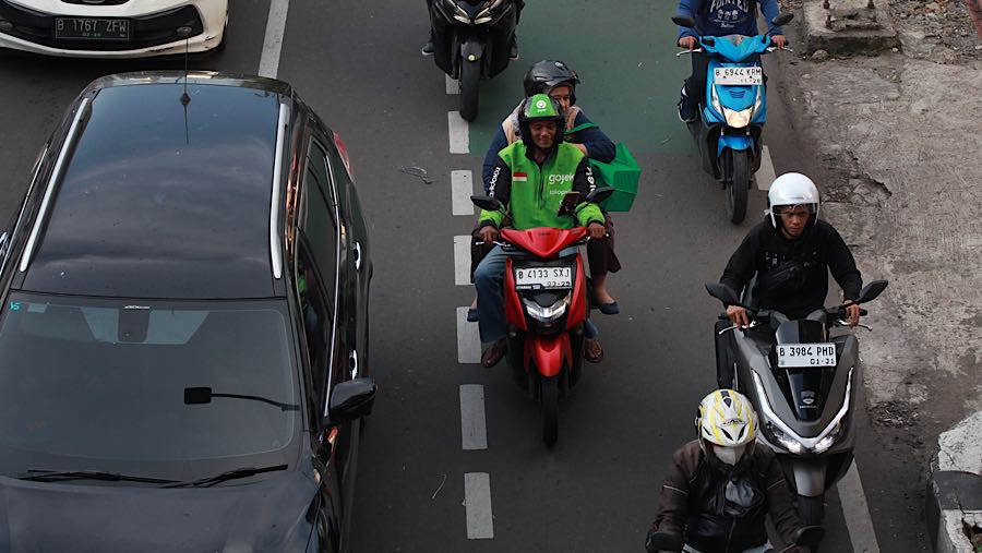 Driver ojol mengendarai motornya di Jalan Mampang Prapatan, Jakarta, Jumat (13/3/2026). (Bloomberg Technoz/Andrean Kristianto)