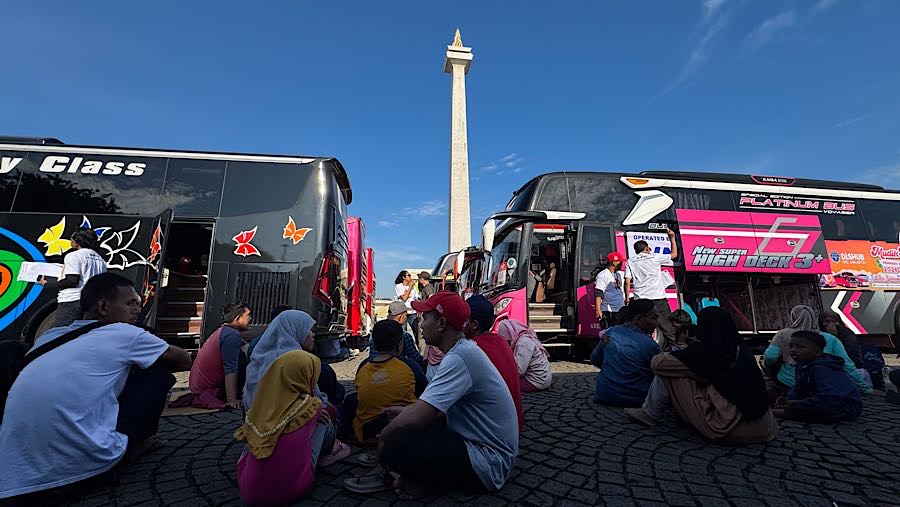 Peserta mudik gratis Pemprov DKI Jakarta menunggu keberangkatan bus di Lapangan Silang Monas, Jakarta, Selasa (17/3/2026). (Bloomberg Technoz/Andrean)